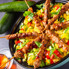 Lamb skewers with curry rice and different vegetables