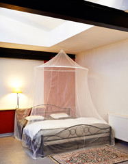 Cosi vintage bed with mosquito Net in a restored loft