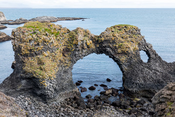 The Cliffs of Arnastapi auf Island mit einer auffallend erodierten schwarzen Steilküste mit...
