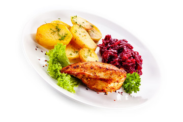 Grilled chicken breast, baked potatoes and vegetables on white background