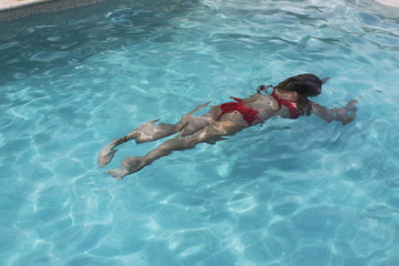 Frau taucht im Swimmingpool im Urlaub