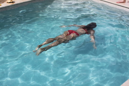 Frau taucht im Swimmingpool im Urlaub