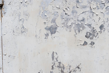 Grunge white metal wall with peeling paint, close-up background photo texture