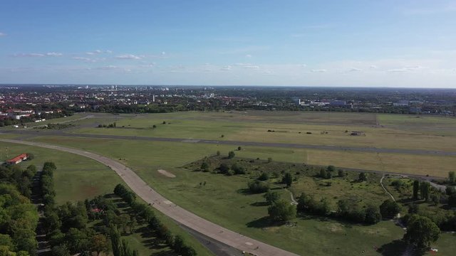 Famous Tempelhofer field in Berlin, Germany. Aerial of taxi runway with bikers and people walking, skating etc.