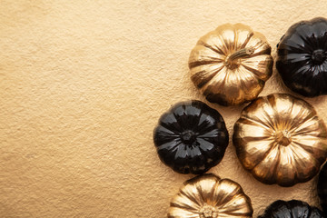 Luxury gold and black autumn pumpkin flat lay composition on a gold background