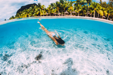 Young attractive woman swimming underwater in transparent blue ocean at Mauritius