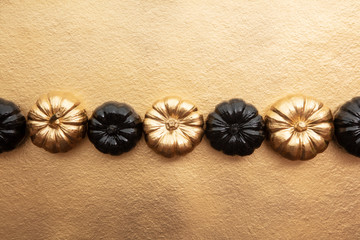 Luxury gold and black autumn pumpkin flat lay composition on a gold background