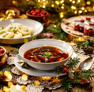 Christmas mushroom soup, a traditional vegetarian  mushroom soup made with dried forest mushrooms in a ceramik plate on a festive table. Polish Christmas dinner