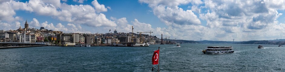 Fototapeta na wymiar Istanbul, Turkey: the breathtaking skyline with the Galata Tower and a ship crossing the Bosphorus for a cruise in the Strait of Istanbul, part of the continental boundary between Europe and Asia