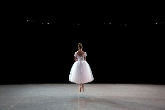 A Ballerina Dancing On A Stage In A Theater