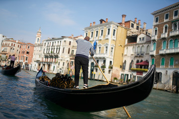 Obraz na płótnie Canvas Venice / Italy - September 29th 2019: Gondolier rowing a gondola in Grand Canal