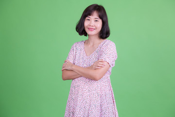 Portrait of happy Asian pregnant woman smiling with arms crossed