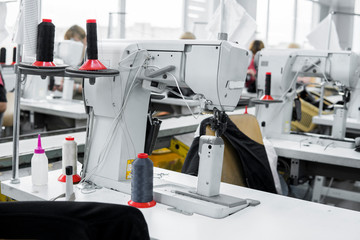 Professional sewing machine with black thread on a shoes factory.