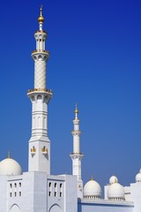 Fototapeta na wymiar minaretes of sheikh zayed grand mosque by deep blue sky