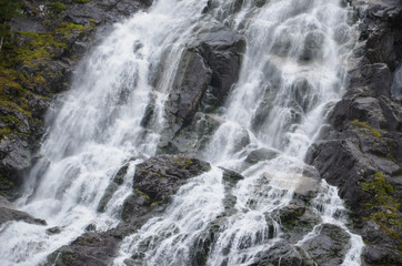 Fototapeta na wymiar Gigantic beautiful waterfall in the Norwegian mountains. Scenic and moody.