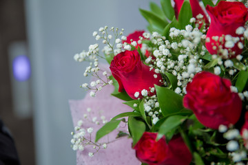 Bouquet of red roses on a dark and white wooden background. Top view . Bouquet of red rose.