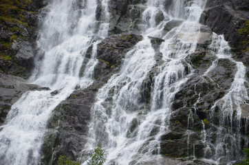 Fototapeta na wymiar Gigantic beautiful waterfall in the Norwegian mountains. Scenic and moody.