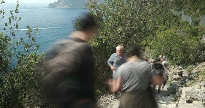 Trekking in the Cinque Terre paths. Time lapse.Many people walk on the paths overlooking the sea.