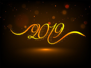 Fototapeta na wymiar Stylized lettering of 2019 on brown background with blurred lighting effect for Happy New year greeting card design.