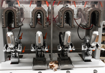 Man use special machine tool for making a shoes. The conveyor on a shoes factory with shoe and sole. Mass production of footwear.