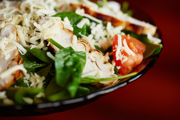 salad with cheese, chicken, spinach, tomato