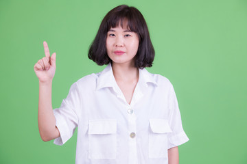 Portrait of beautiful Asian businesswoman pointing up