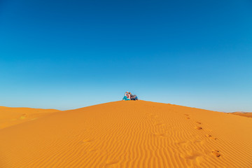 Loving couple in the Sahara desert. Joint rest.