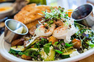 A gourmet Salad with Sprouts and Goat Cheese with ramekins of dressing