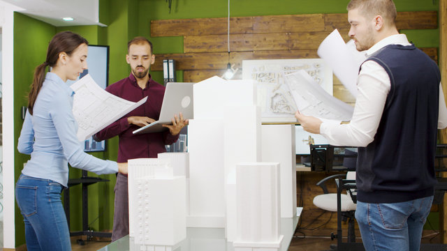Team of architect working on a building project with building models