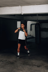 Fototapeta na wymiar Handsome young boxer during boxing exercises