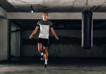 Athletic attractive man jumping on a rope