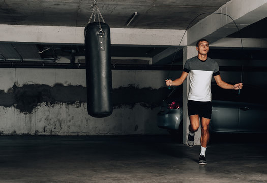 Young athlete jumping rope at an abandoned building, working out