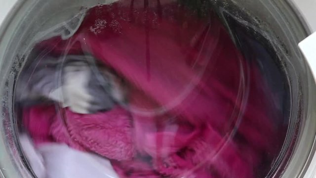 Lavatrice in funzione mentre pulisce capi colorati