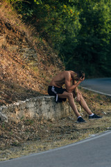 Handsome athlete man tired after long run in the mountain