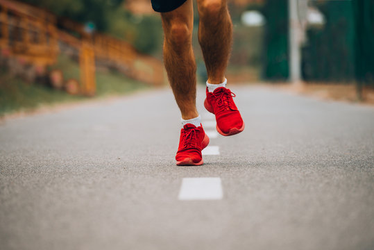 Runner Feet Running On Road Close-up On Shoe. Man Fitness On Track