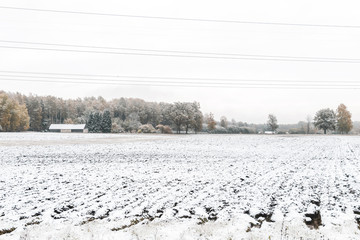 Winter landscape with first snow in the countryside fields with late autumn colors