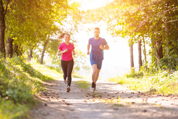 Fototapeta premium young couple jogging on sunny day at nature