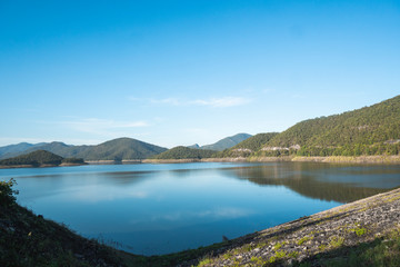 Naklejka na ściany i meble Beautiful lake surrounded by mountains on a sunny day.