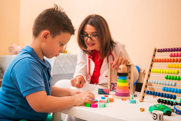Fototapeta premium Doctor and young boy play with toys at doctor's office
