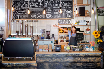 Coffee shop is open - woman at workplace at new open café.