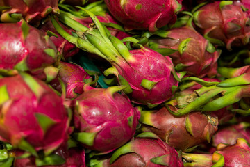Dragon fruit with a lots of dragon fruit on a background. Dragon fruit or pitaya. Tropical and exotic fruits. Healthy and vitamin food concept.