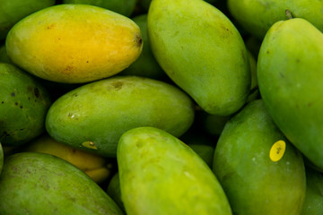 Texture of green juicy fresh mango fruit. Group of fresh green mango for sell .Thai fruit tropical raw mangoes. Tropical and exotic fruits. Healthy and vitamin food concept.