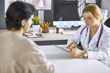 Fototapeta premium young woman doctor takes patient in office