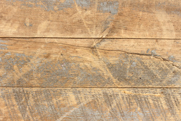 The surface of an old wooden board, weathered and faded in the sun.