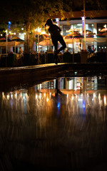 Obraz na płótnie Canvas Bokeh backlight girl silhouette after rain on the street at night
