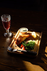 Portion of salmon fillet with herbs on a wooden table. Top view