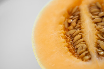 Fresh sweet orange melon on the white plate as a background with a selective focusing. Useful and vitamin-rich food. Vegeterian.