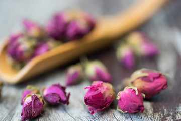 Buds of dried roses for tea in a spoon wooden