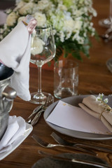 The beautiful arrangement on the wooden table, white roses and ceramic plates. Boho chic wedding table setting.