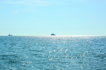 Sea travel. Beautiful view of the waves on a bright sunny day. Sun glare on the water. Ships sail...